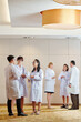 © DragonImages - Scientists standing in hall and talking about new researches that were discussing during conference