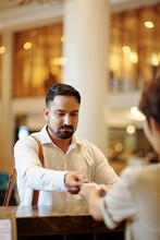 Bearded Serious Man Returning Electronic Room Key To Manager At Hotel Reception
