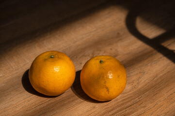 oranges in the afternoon light on wooden table