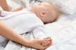 © Pixel-Shot - Mother with little baby sleeping on bed