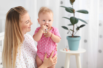 Happy mother with cute little baby at home