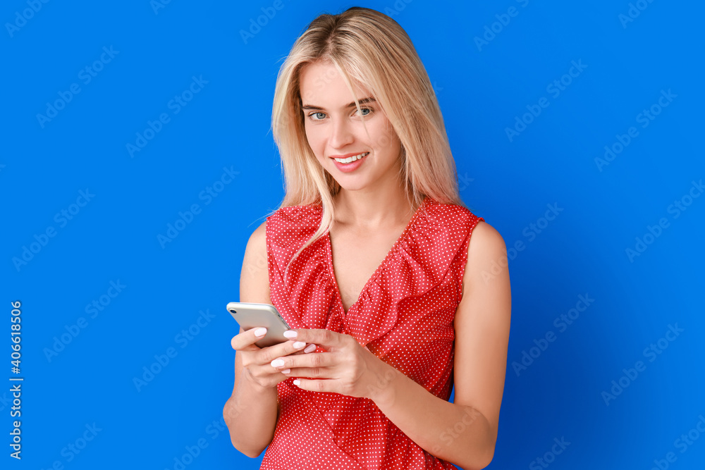 Beautiful young woman with mobile phone on color background