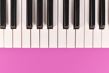 Electric keyboard piano keys on pink background with empty copy space