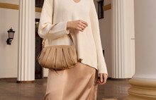 Closeup Beige Leather Bag In Hand Of Fashion Woman In Silk Skirt. Elegant Fall And Spring Outfit.