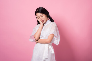 Happy cheerful young woman wearing her black hair rejoicing at positive news or birthday gift, looking at camera with joyful and charming smile. Asian girl portrait on pink background in studio