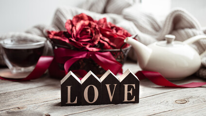 A romantic composition for Valentine's Day with the decorative word love and decor details.