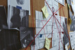 Detective board with crime scene photos, map and clues connected by red string, closeup