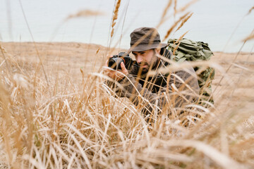 Focused photographer taking photo on digital camera outdoors