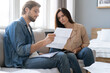 © opolja - Photo of cheerful young couple analyzing their finances with documents