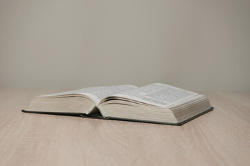 Aufkleber - Open holy bible on a  wooden table. Beautiful white wall background.