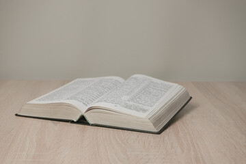 Aufkleber - Open holy bible on a  wooden table. Beautiful white wall background.