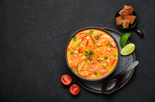 Moqueca With Fish And Shrimps In Black Bowl On Dark Slate Table Top. Brazilian Sea Food Curry Dish With Coconut Milk And Vegetables. Top View. Copy Space