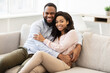 © Prostock-studio - African american couple spending weekend together lying on sofa