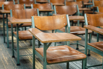 wooden lecture chairs arranged in the classroom. empty college classroom with many vintage wooden le