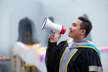 Male graduate shouting with megaphone