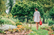 © Vladimir Borovic - Beautiful young female in garden taking care of plants and flowers. Pretty girl taking care of garden. Watering flowers from watering can in summer time