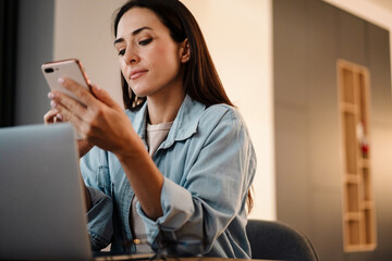 Wall Mural - Beautiful woman using mobile phone and laptop computer