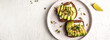 healthy toasts with avocado, cheese and whole wheat rye bread on a plate. tasty Italian meal. Long banner format. Top view, copy space