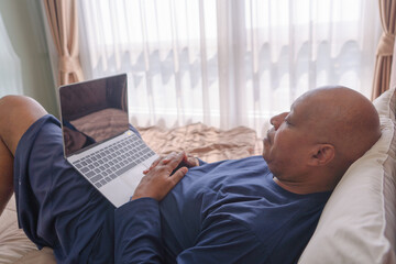 Wall Mural - Happy smiling business, black man, African American people working from home and talking to colleagues in webcam video call conference with computer and blank screen in quarantine on bed. Lifestyle