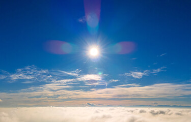 Aerial view from above of white puffy clouds in bright sunny day.