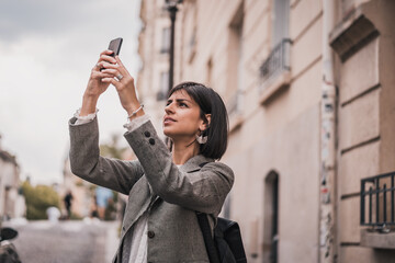 Wall Mural - Young urban business woman talking on phone on city street 