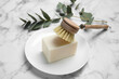 Cleaning brush and soap bar for dish washing on white marble table