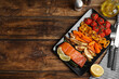 Tasty cooked salmon and vegetables served on wooden table, flat lay with space for text. Healthy meals from air fryer
