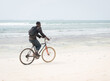 © Jasmin Merdan - African young man riding bike on tropical beach
