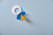Baby Blue Pacifier On A Blue Background, Place For An Inscription