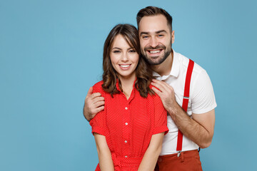 Sticker - Smiling cheerful young couple two friends man woman wearing white red clothes hugging looking camera isolated on pastel blue color background studio portrait. St. Valentine's Day holiday concept.