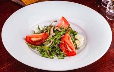 Wall Mural - Beef tongue salad with arugula, tomatoes and quail egg on white plate