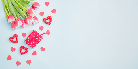 flat lay valentines day frame with pink tulips and gift box on a light green background
