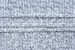 White and blue knit texture. Close up of wool material pattern.  Defect on knitwear, snag. 