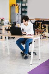 Wall Mural - young mexican man meditating and doing yoga in office in Latin America