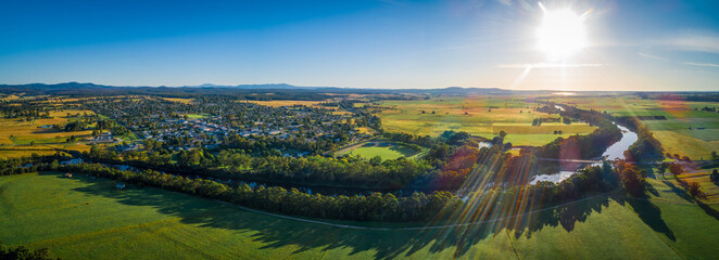 Canvas Print - Snowy River meanders around small rural town and meadows at sunset - aerial panoramic landscape