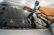 Car window tinting. Process of Installation window tint in Car Detailing Studio Garage by professional detailer.