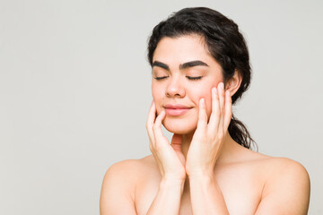 Wall Mural - Relaxed young woman touching her skin after showering