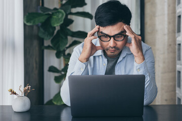 sad depression serious people from work,study stress concept.asian man feeling tired suffering using computer working work place.concept global economic,health problems