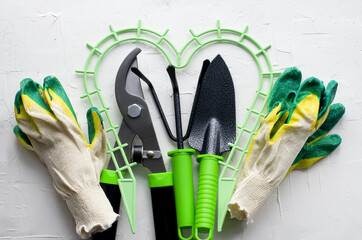 Gardening tools on white background, flat lay, copy space text, top view. Concept of hobby, springtime, garden maintenance, landscaping, transplanting plants, gardening at home,  planting