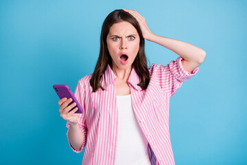 Sticker - Photo portrait of panicking woman with open mouth touching head holding phone in one hand isolated on pastel blue colored background