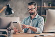 © deagreez - Photo portrait of man using tablet working at table in modern industrial office indoors