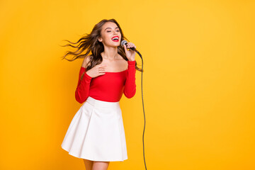 Sticker - Photo portrait of dreamy girl performing song on festival keeping microphone isolated on bright yellow color background