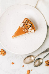 Canvas Print - A piece of cheesecake with salted caramel and nuts on a plate.