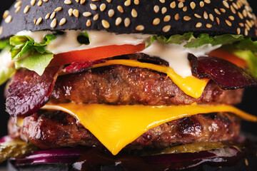 Wall Mural - Yummy black burger grilled with double meat cutlet and melted cheese, close up.