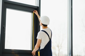 male industrial builder worker at window installation in building construction site