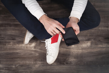 Man using smartphone at home.