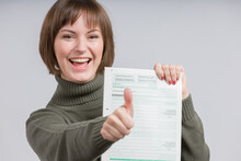 Happy Woman Presents A Tax Declaration Form And Shows Thumbs Up