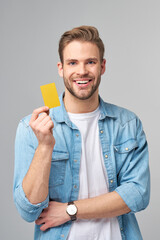 Wall Mural - Handsome happy young man showing blank bank cor discount card