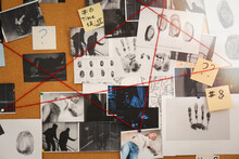 Detective Board With Crime Scene Photos, Stickers, Clues And Red Thread, Closeup