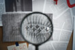 © New Africa - Looking through magnifying glass at photo of footprint on detective board, closeup